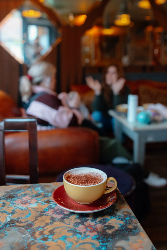 coffee in foreground, baby lounge mums in background